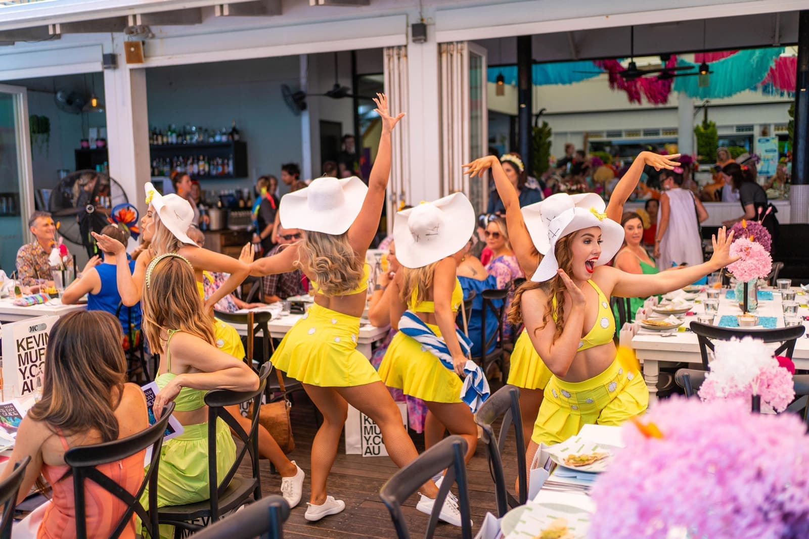 Melbourne Cup day at Nu Nu: performers in white hats and yellow outfits dancing between the tables